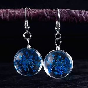 Glass ball earrings with real blue dried flowers inside.